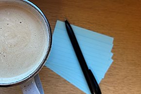Kaffeetasse mit Karteikarten und Stift